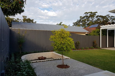 Geometrischer, Mittelgroßer Klassischer Garten hinter dem Haus mit Feuerstelle und direkter Sonneneinstrahlung in Brisbane