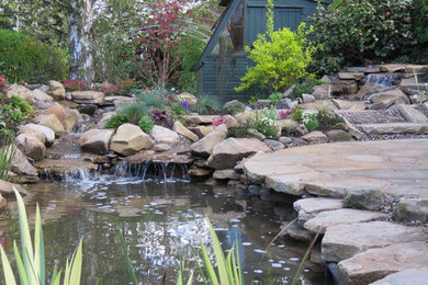 Inspiration for a rustic back garden in Other with a water feature and natural stone paving.