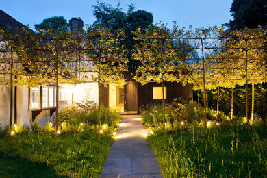 Cette image montre un jardin arrière rustique avec une exposition partiellement ombragée et des pavés en pierre naturelle.