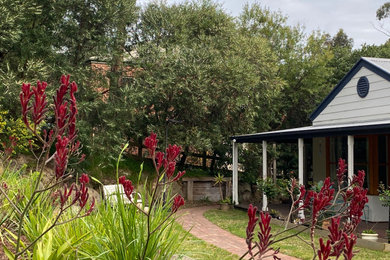 Diseño de jardín bohemio extra grande en patio trasero con jardín francés, privacidad, exposición total al sol y adoquines de ladrillo