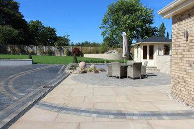 Photo of a large contemporary back full sun garden for summer in Other with natural stone paving.