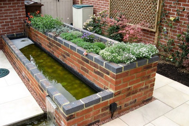 Inspiration for a small contemporary back formal partial sun garden for summer in Other with a water feature and natural stone paving.