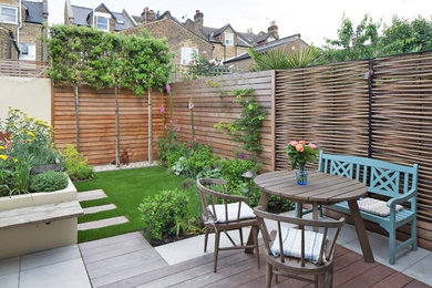 This is an example of a farmhouse back garden in London with a garden path and concrete paving.