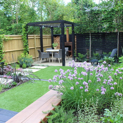This is an example of a small contemporary partial sun backyard formal garden in Hampshire with decking for summer.