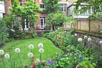 Design ideas for a classic back garden in London with natural stone paving.