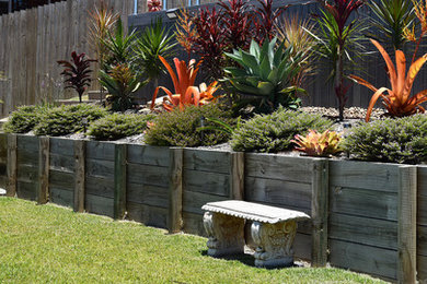 Mittelgroße Gartenmauer hinter dem Haus mit direkter Sonneneinstrahlung und Dielen in Brisbane