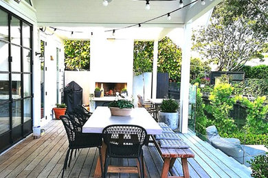 高級な広いコンテンポラリースタイルのおしゃれな裏庭 (屋外暖炉、デッキ材舗装) の写真