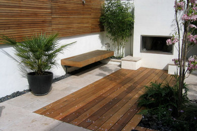 Diseño de jardín actual de tamaño medio en verano en patio trasero con brasero, exposición parcial al sol y adoquines de piedra natural