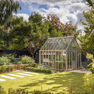 Traditional partial sun garden in Other with a wood fence.