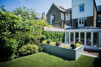 Imagen de jardín actual de tamaño medio en patio trasero con jardín vertical y exposición total al sol