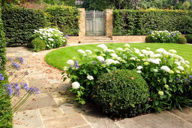Photo of a large traditional backyard landscaping in London.