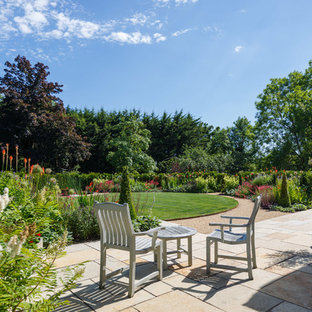 Photo of a large classic back full sun garden in Gloucestershire with natural stone paving.