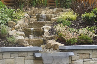 Design ideas for a traditional back formal full sun garden for summer in Other with a water feature and natural stone paving.