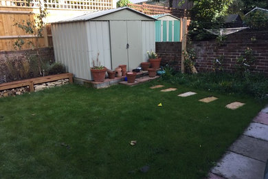 Cette image montre un petit jardin arrière traditionnel avec une exposition partiellement ombragée.