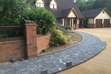 Design ideas for a large modern front driveway garden in Hertfordshire with concrete paving.