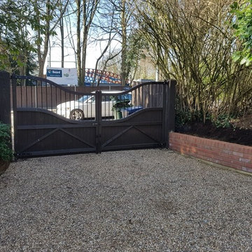 Wooden double gates with fencing and brick walls