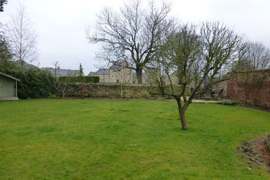 Cette image montre un jardin arrière rustique de taille moyenne et l'été avec une exposition partiellement ombragée et des pavés en pierre naturelle.
