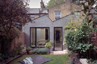Diseño de jardín minimalista pequeño en primavera en patio trasero con borde del césped, exposición parcial al sol, adoquines de piedra natural y con madera
