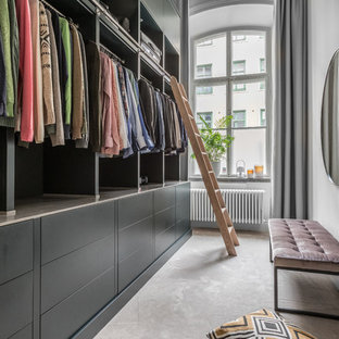 Inredning av ett klassiskt stort walk-in-closet för könsneutrala, med öppna hyllor, svarta skåp, heltäckningsmatta och beiget golv