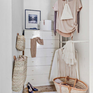 Bild på ett litet minimalistiskt walk-in-closet för kvinnor, med öppna hyllor, vita skåp, ljust trägolv och brunt golv