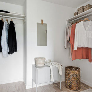 Inspiration för ett minimalistiskt walk-in-closet för könsneutrala, med ljust trägolv och beiget golv