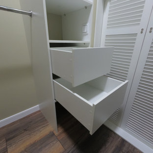 Bild på ett mellanstort vintage walk-in-closet för könsneutrala, med luckor med lamellpanel, vita skåp, laminatgolv och brunt golv