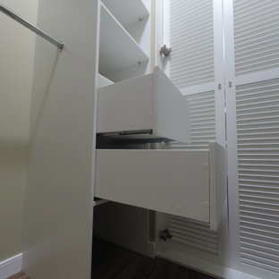 Imagen de armario vestidor unisex, clásico renovado, de tamaño medio, con armarios con puertas mallorquinas, puertas de armario blancas, suelo laminado y suelo marrón