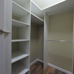 Modelo de armario vestidor unisex, tradicional renovado, de tamaño medio, con armarios con puertas mallorquinas, puertas de armario blancas, suelo laminado y suelo marrón