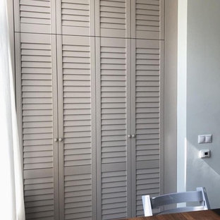 Bild på ett mellanstort vintage klädskåp, med luckor med lamellpanel och beige skåp