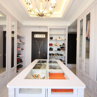 Imagen de armario vestidor de mujer, bohemio, grande, con armarios con paneles empotrados, puertas de armario de madera clara, suelo de madera en tonos medios y suelo beige