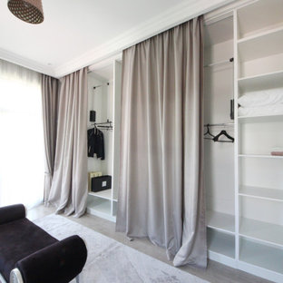 Foto de armario vestidor de mujer, ecléctico, grande, con armarios abiertos, puertas de armario de madera clara, suelo de madera en tonos medios y suelo beige