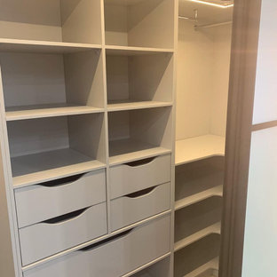 Esempio di una piccola cabina armadio per uomo industriale con pavimento in laminato e pavimento beige