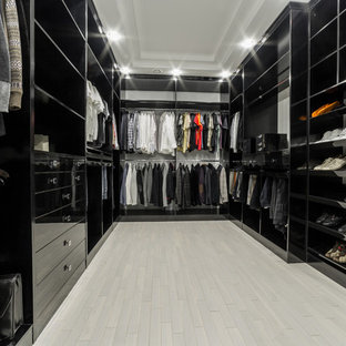 Esempio di una cabina armadio unisex chic di medie dimensioni con ante con bugna sagomata, pavimento in marmo, ante nere e pavimento grigio