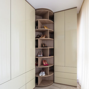 Foto de armario vestidor de mujer, actual, de tamaño medio, con armarios con paneles lisos, puertas de armario beige, suelo de baldosas de porcelana y suelo beige