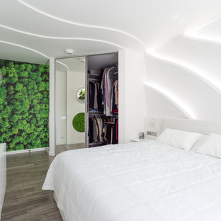 Immagine di una cabina armadio unisex minimal di medie dimensioni con ante di vetro, pavimento in bambù e pavimento grigio