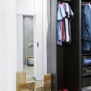 Esempio di una piccola cabina armadio per uomo industriale con ante lisce, ante in legno bruno, pavimento in laminato e pavimento marrone