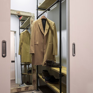 Foto di una piccola cabina armadio per uomo industriale con pavimento in laminato, nessun'anta e pavimento marrone