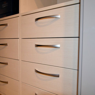 Diseño de armario vestidor de hombre, contemporáneo, pequeño, con armarios con paneles lisos, puertas de armario de madera clara, suelo de baldosas de porcelana y suelo beige