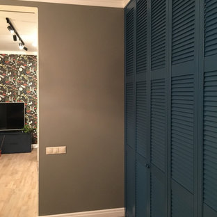 Imagen de armario vestidor escandinavo, grande, con armarios con puertas mallorquinas, puertas de armario azules, suelo laminado y suelo beige
