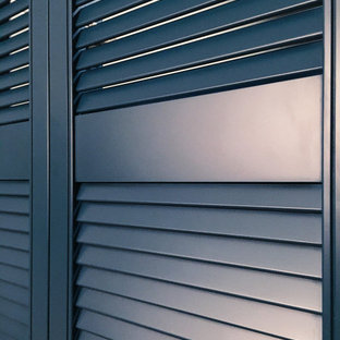 Esempio di una grande cabina armadio nordica con ante a persiana, ante blu, pavimento in laminato e pavimento beige