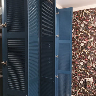 Foto de armario vestidor nórdico, grande, con armarios con puertas mallorquinas, puertas de armario azules, suelo laminado y suelo beige