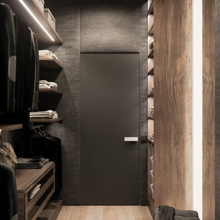Ejemplo de armario vestidor unisex, nórdico, de tamaño medio, con armarios con paneles lisos, puertas de armario de madera oscura, suelo de madera clara y suelo beige