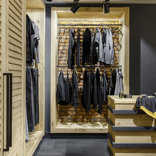 Idée de décoration pour un dressing room urbain pour un homme avec un placard sans porte et un sol gris.