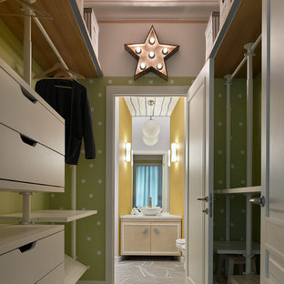 Immagine di una piccola cabina armadio unisex minimal con ante bianche, pavimento in cemento, pavimento bianco e ante lisce