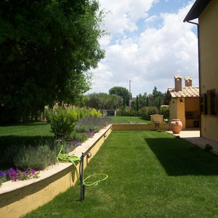 Großer, Geometrischer Country Vorgarten im Frühling mit Kamin, direkter Sonneneinstrahlung und Pflasterklinker in Florenz
