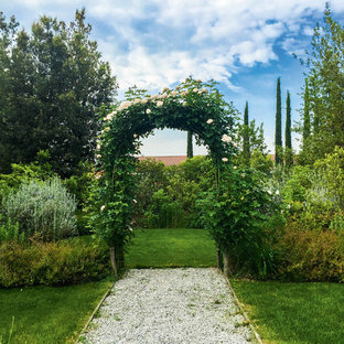 Idee per un grande giardino formale mediterraneo esposto a mezz'ombra in primavera con ghiaia