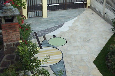 Ejemplo de jardín ecléctico en patio con adoquines de piedra natural