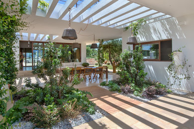 Ejemplo de acceso privado mediterráneo de tamaño medio en patio con exposición parcial al sol y entablado
