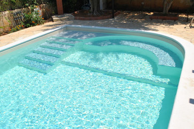 Ispirazione per una piscina mediterranea di medie dimensioni e dietro casa con pavimentazioni in pietra naturale