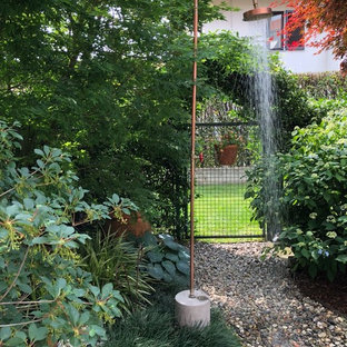 Immagine di un piccolo giardino industriale in ombra dietro casa in primavera con un ingresso o sentiero e ghiaia